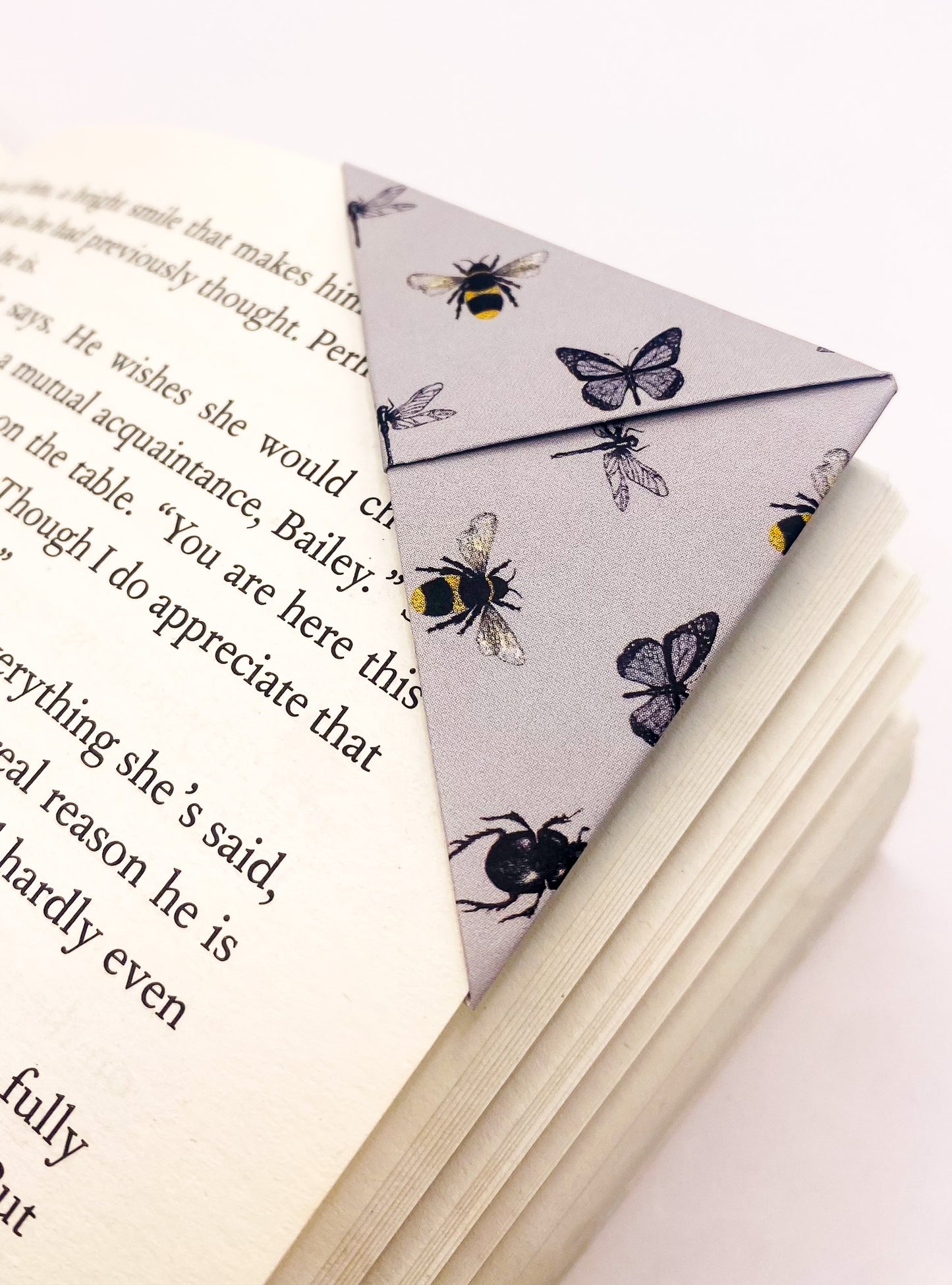 Origami insect bookmark on the corner of a book