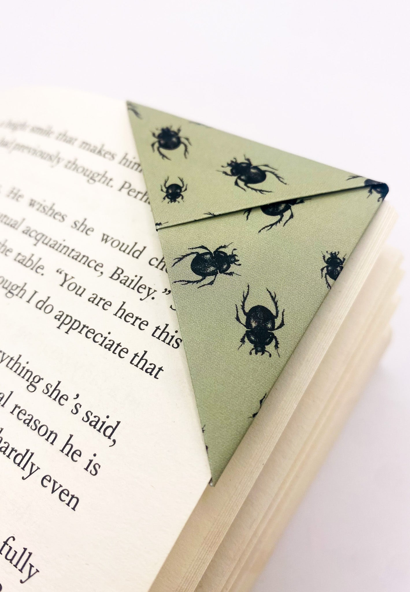 Origami insect bookmark on the corner of a book