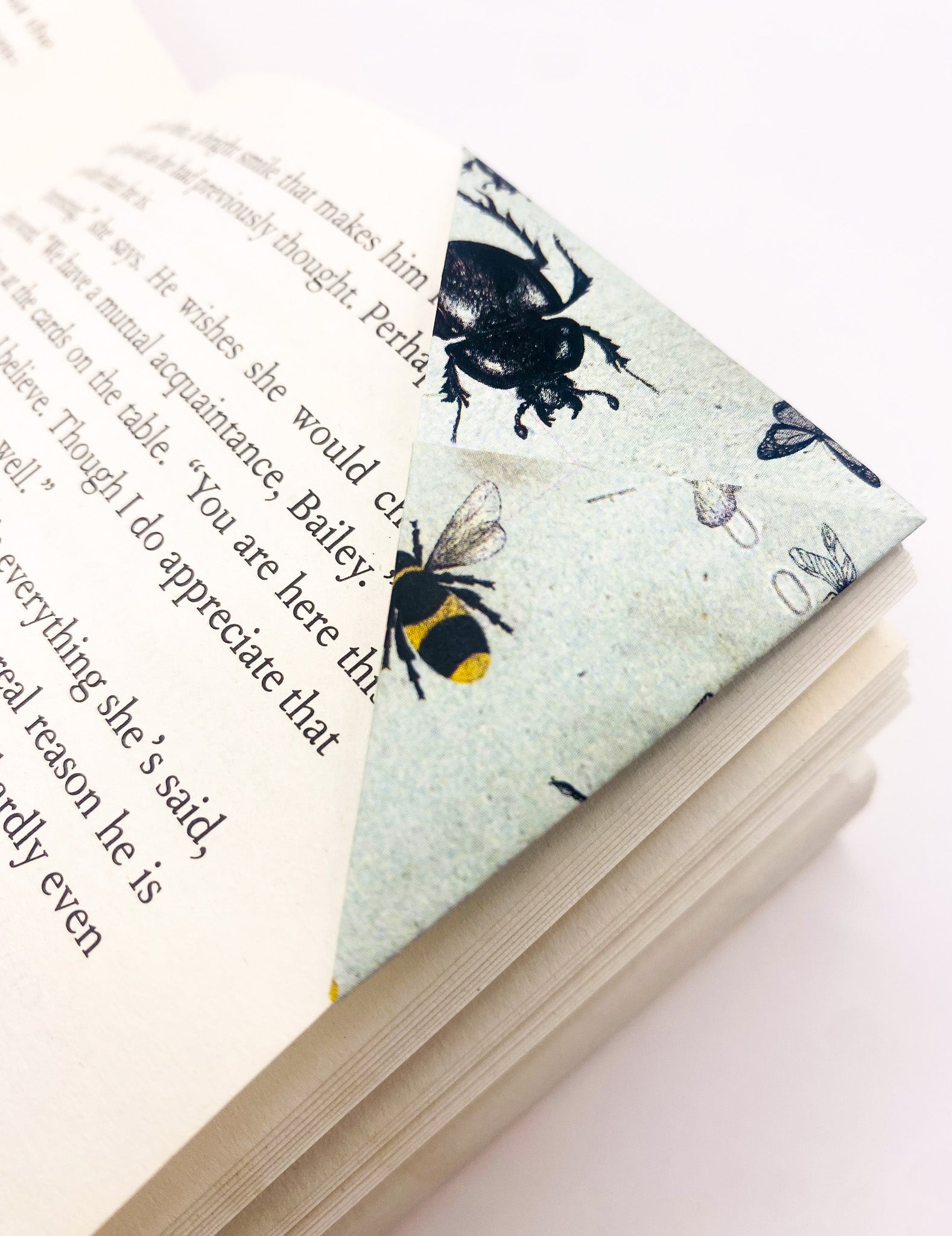 Origami insect bookmark on the corner of a book