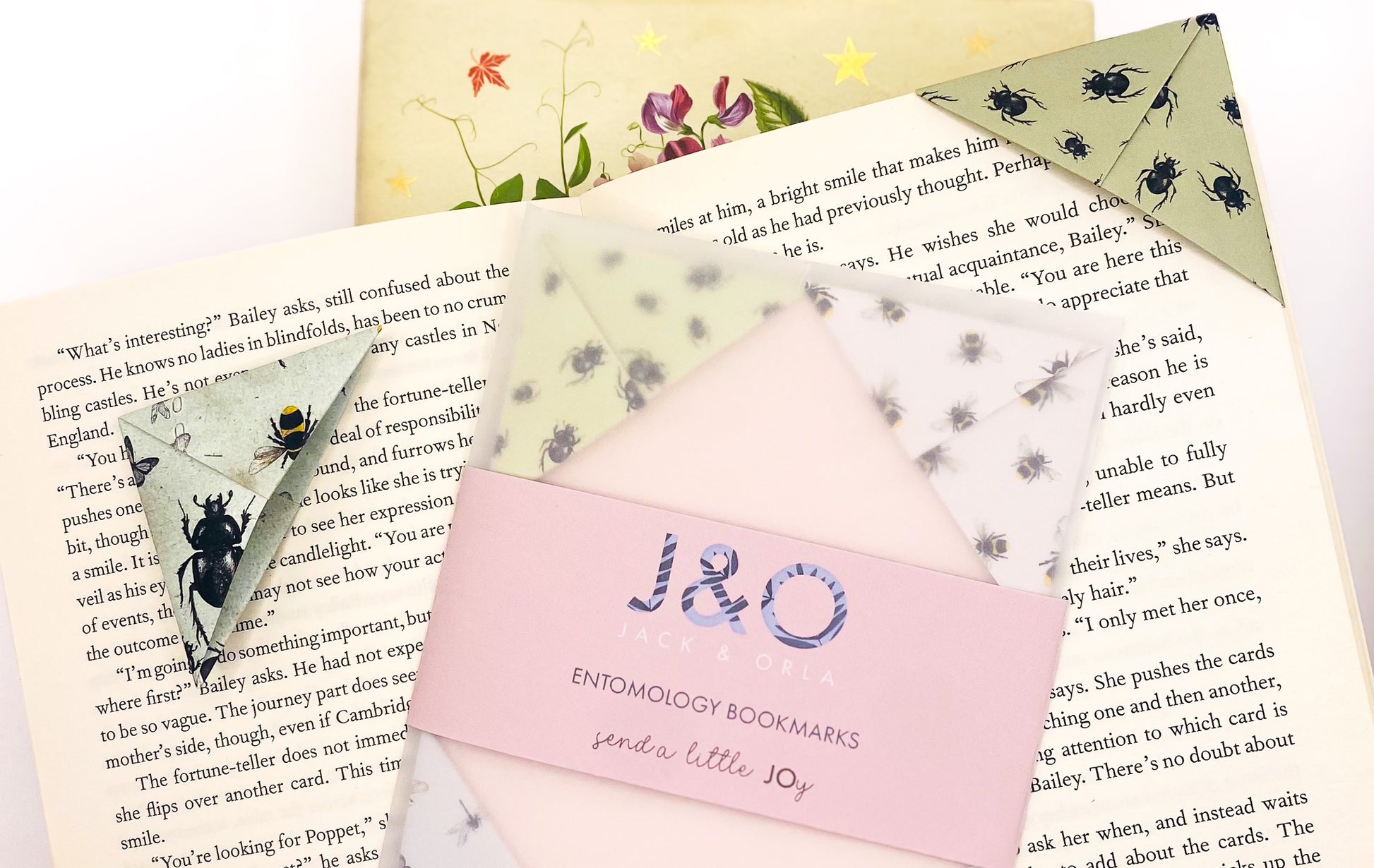 A book with an origami insect bookmark on the corner with a set of bookmarks 