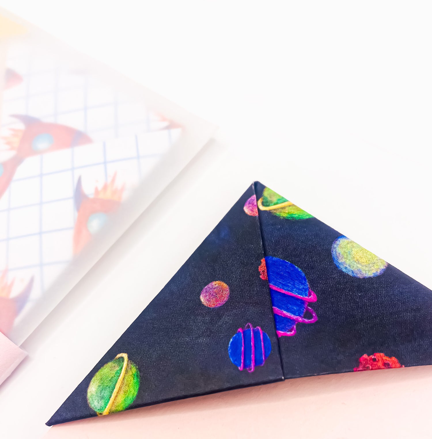 A close up image of a space themed origami bookmark