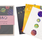 A photo featuring three of the designs in the space themed postcard gift set, as well as a packaged set. The front postcard features a square grid background with four brightly coloured planets.